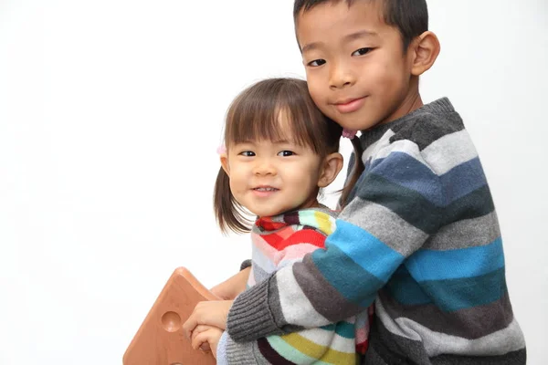 日本の兄と妹のロッキング ホース (7 歳の男の子と 2 年古い女の子と遊んで) — ストック写真