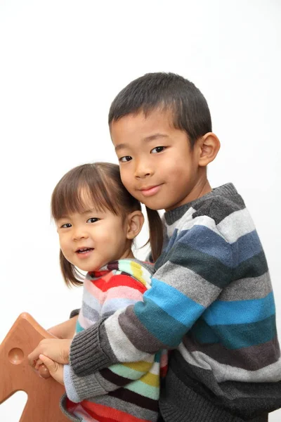 日本の兄と妹のロッキング ホース (7 歳の男の子と 2 年古い女の子と遊んで) — ストック写真