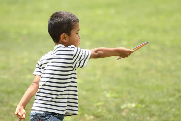 Japonês menino jogando disco voador (primeira série na escola primária ) — Fotografia de Stock