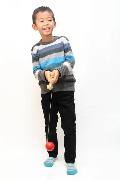 Japansk pojke spelar cup och bollen (första klass i grundskolan) — Stockfoto