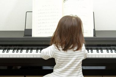 Japanese girl playing a piano (2 years old) clipart