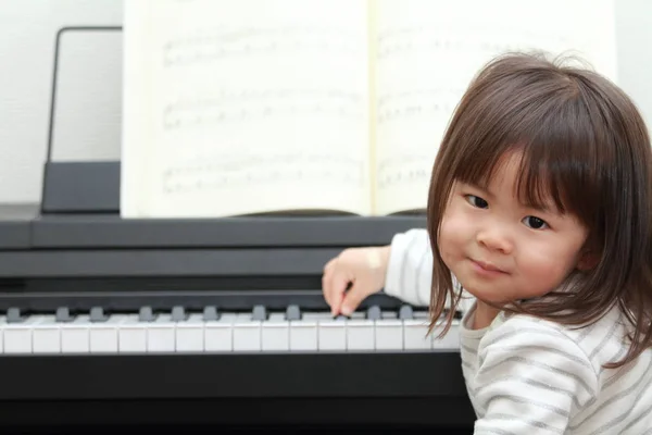 Japans meisje spelen een piano (2 jaar oud) — Stockfoto