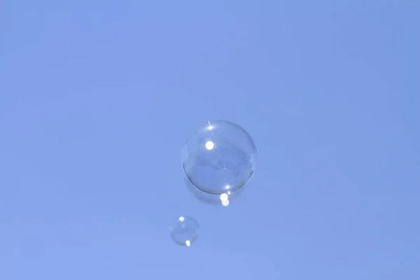 Plovoucí bubliny mýdlo na modré obloze — Stock fotografie