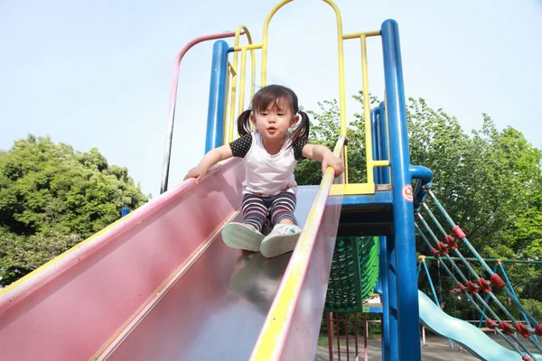 Japanisches Mädchen auf der Rutsche (2 Jahre alt)) — Stockfoto
