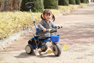 Japanese girl riding on the tricycle (2 years old) clipart