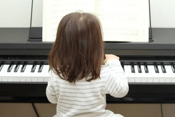 Japanisches Mädchen spielt Klavier (2 Jahre alt)) — Stockfoto