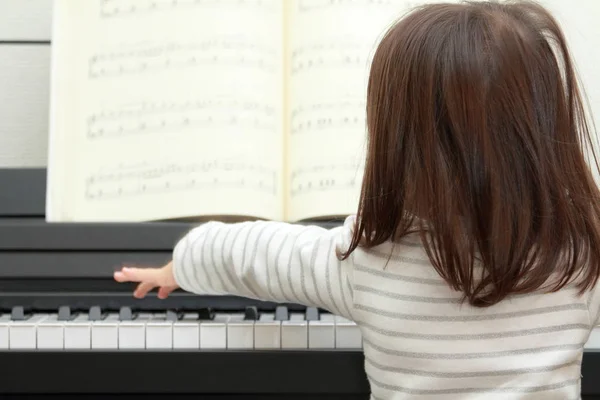 Japonesa chica jugando un piano (2 años) ) — Foto de Stock