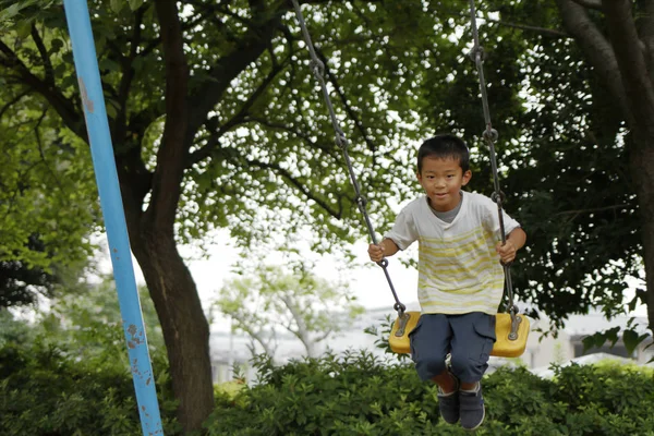 Japanese boy on the swing (second grade at elementary school) — Stock Photo, Image