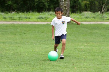 Japon çocuk futbol topuyla oynayan (ikinci sınıf ilköğretim okulunda)