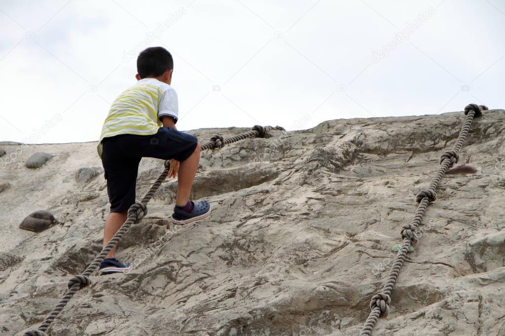 Japanese boy climbing on the wall (second grade at elementary school)