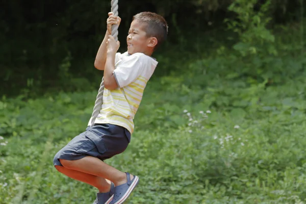 Japanese boy playing with flying fox (second grade at elementary school) — Stock Photo, Image