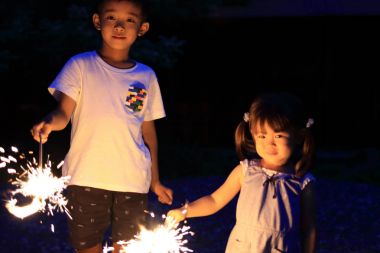 Japon kardeşi ve kız kardeşi el havai fişek (7 yaşında çocuk ve 2 yıl yaşlı kız yapıyor)