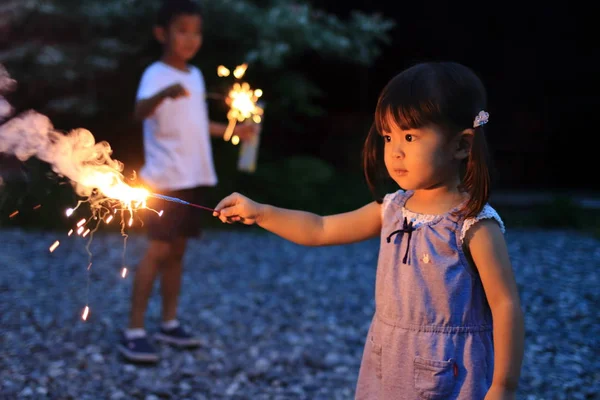 Japon kardeşi ve kız kardeşi el havai fişek (7 yaşında çocuk ve 2 yıl yaşlı kız yapıyor)