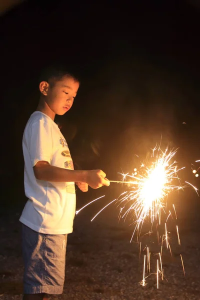 Japanese boy doing handheld fireworks (second grade at elementary school)