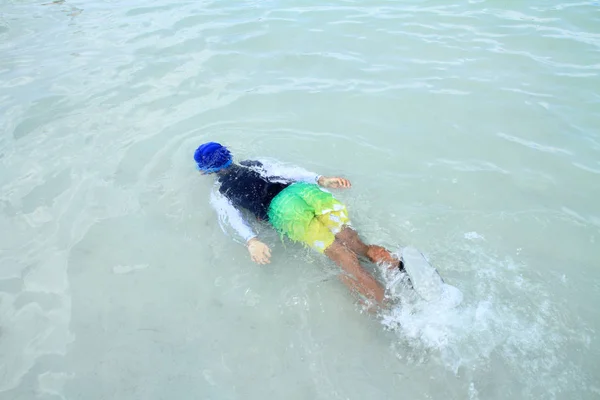 Japanischer Junge schwimmt im Meer (zweite Klasse der Grundschule)) — Stockfoto