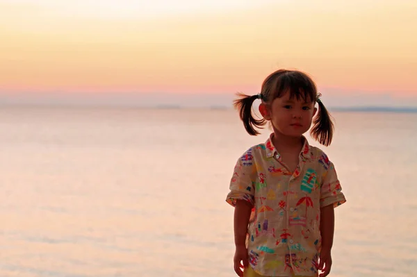 Japanisches Mädchen steht in Rot am Meer (2 Jahre alt)) — Stockfoto