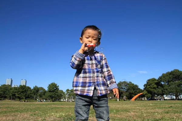 Japonês menino brincando com bolha (3 anos de idade) na grama — Fotografia de Stock