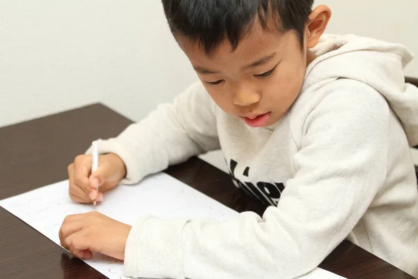 Японський хлопець робить домашнє завдання (перший сорт в початковій школі) — стокове фото