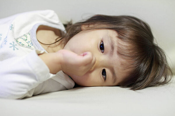 lying Japanese girl with sucking her finger (2 years old)