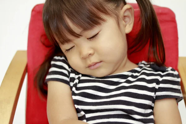 สาวญี่ปุ่นนอนบนเก้าอี้ (2 ปี ) — ภาพถ่ายสต็อก