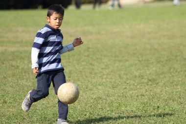 Japon çocuk futbol topuyla oynayan (ikinci sınıf ilköğretim okulunda)