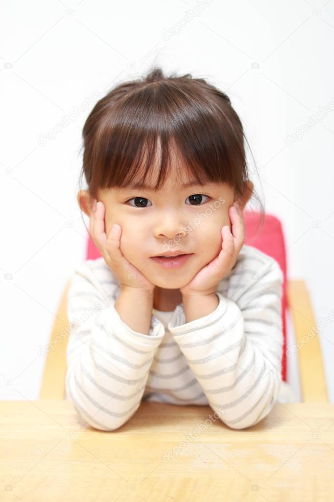 Japanese girl resting her chin in her hands (3 years old)