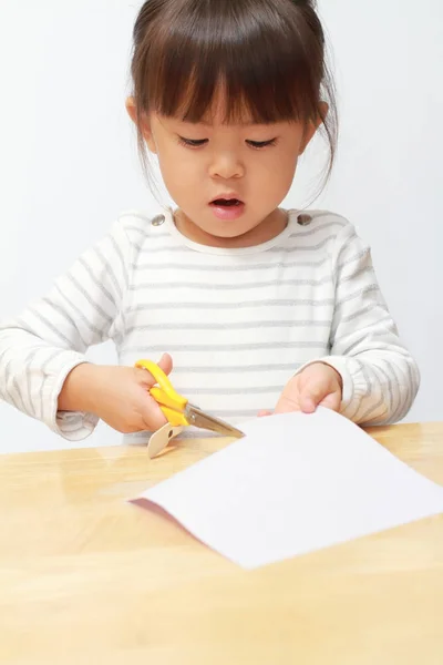 Menina japonesa cortando papel com tesoura (3 anos de idade ) — Fotografia de Stock