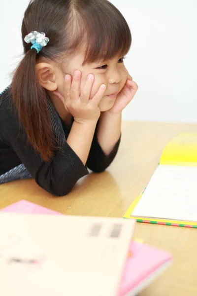 Niña japonesa leyendo un libro con la barbilla en las manos (3 años) ) — Foto de Stock