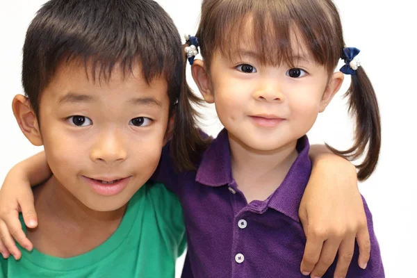 Japonés hermano y hermana poniendo brazos alrededor de la otra sholders (8 años de edad, niño y 3 años de edad, niña ) —  Fotos de Stock