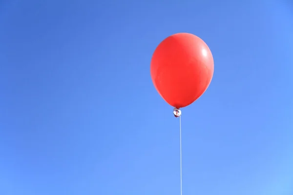 Красный шарик под голубым небом — стоковое фото
