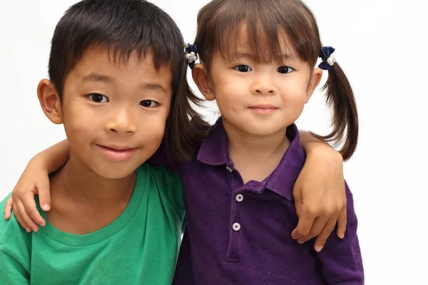 Japonés hermano y hermana poniendo brazos alrededor de la otra sholders (8 años de edad, niño y 3 años de edad, niña ) —  Fotos de Stock