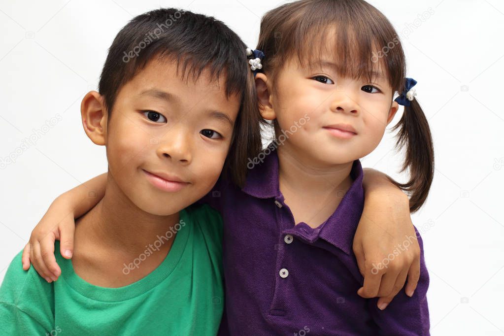 Japanese brother and sister putting arms around each other's sholders (8 years old boy and 3 years old girl)