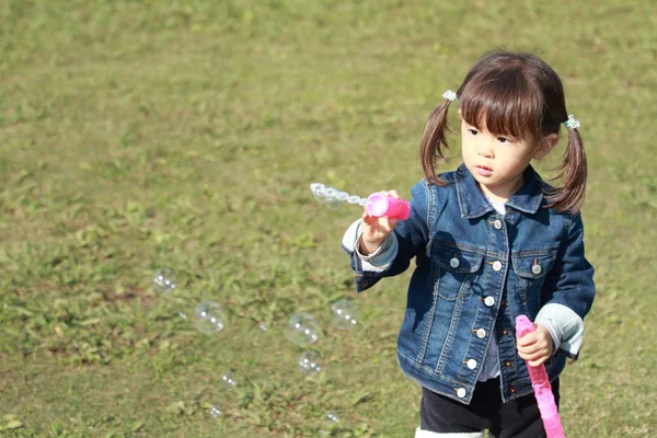 日本の女の子 (3 歳) がバブルで遊んでください。 — ストック写真
