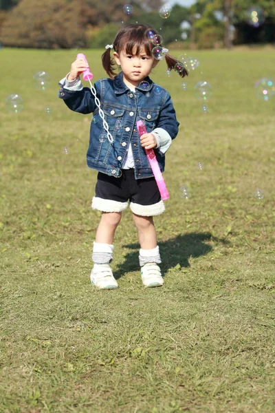 Японская девочка (3 года), играющая с пузырем — стоковое фото