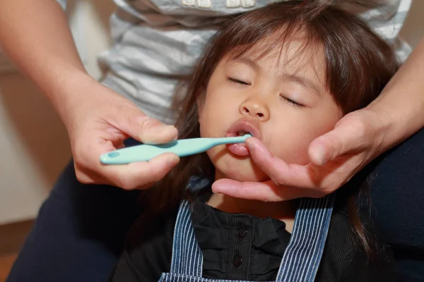 Japansk flicka vars tänder är borstat av hennes mon (3 år gammal) — Stockfoto