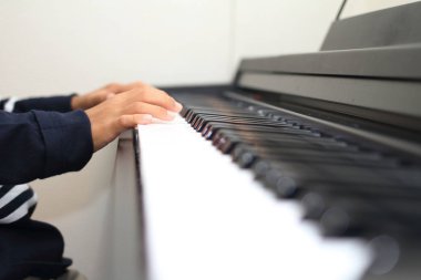 Japon çocuk bir piyano çalan eller (ikinci sınıf ilköğretim okulunda)