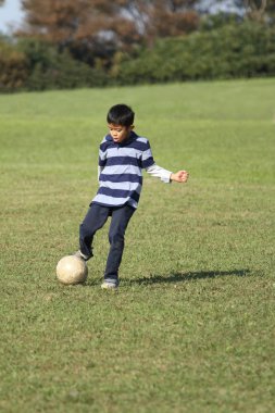 Japon çocuk futbol topuyla oynayan (ikinci sınıf ilköğretim okulunda)