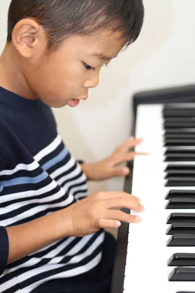 Japanischer Junge beim Klavierspielen (zweite Klasse der Grundschule)) — Stockfoto