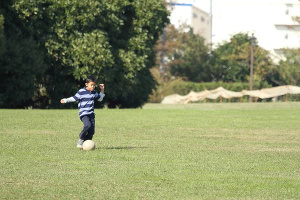 Japanse jongen spelen met voetbal (tweede leerjaar op de basisschool) — Stockfoto