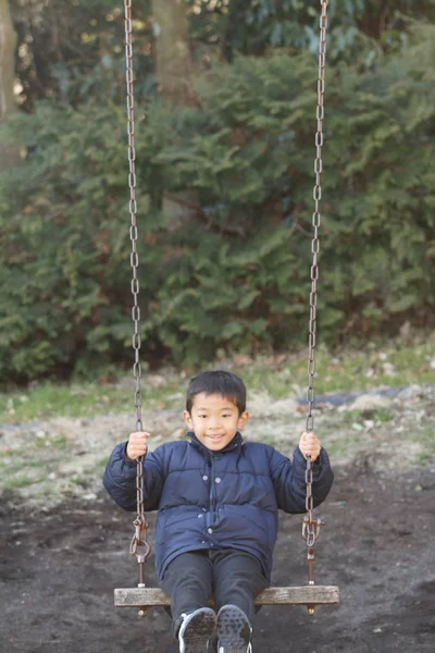 Giapponese ragazzo su il swing (secondo grado a elementare scuola ) — Foto Stock