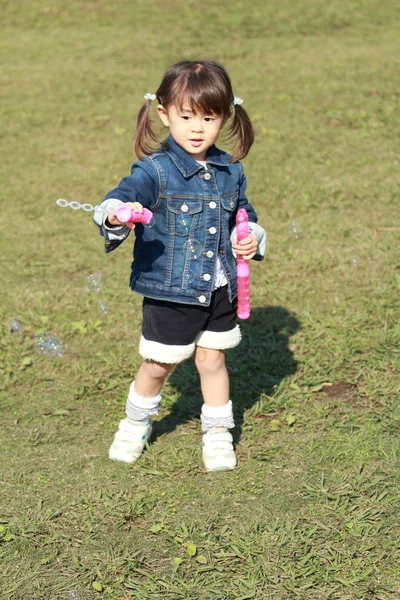 Menina japonesa (3 anos) brincando com bolha — Fotografia de Stock