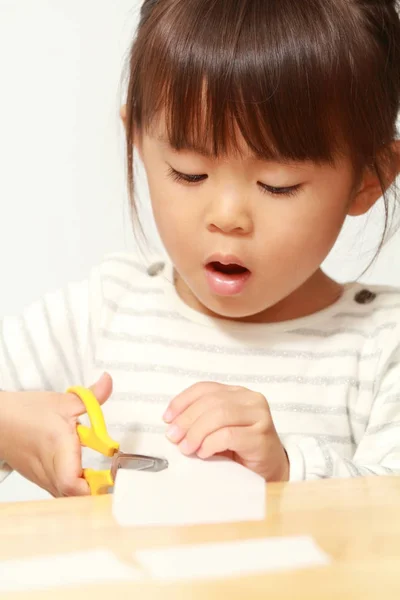 Menina japonesa cortando papel com tesoura (3 anos de idade ) — Fotografia de Stock