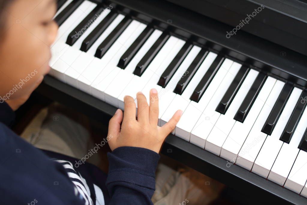 Japanese boy playing a piano (second grade at elementary school)