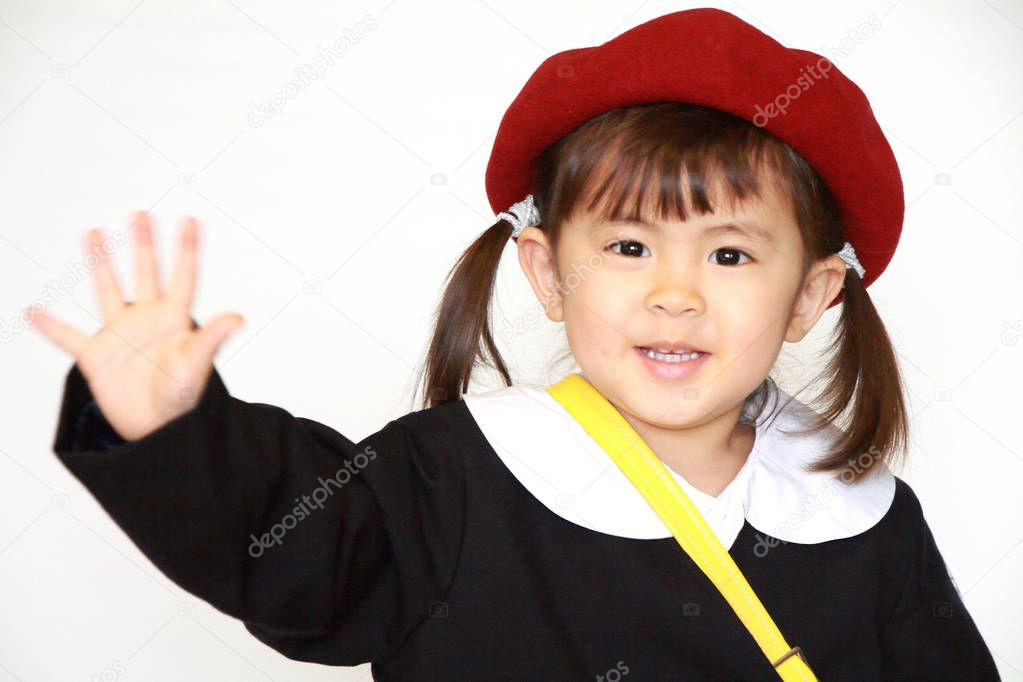 Japanese girl in kindergarten uniform waving her hand (3 years old)