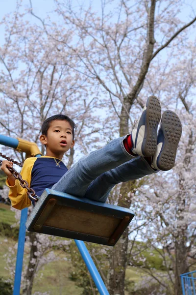 ブランコに乗っている日本少年 (小学校 3 年生) — ストック写真