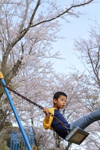 Японський хлопець на гойдалки (третій клас в початковій школі) — стокове фото