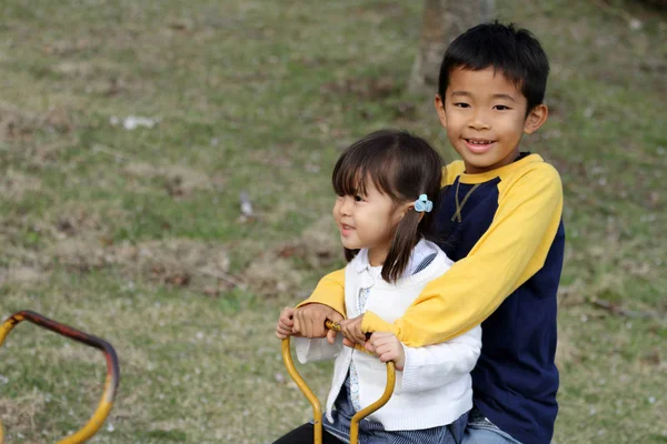 Japonský bratr a sestra na houpačce (8 let a 3 roky stará dívka) — Stock fotografie