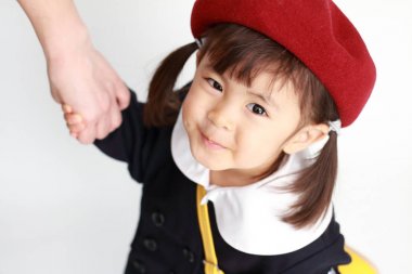Japon kız annesinin el (3 yaşında clasping anaokulu üniformalı)
