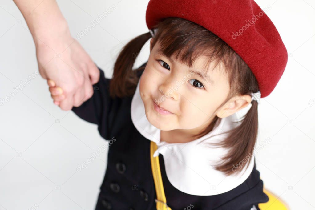 Japanese girl in kindergarten uniform clasping her mother's hand (3 years old)