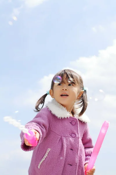 Japanisches Mädchen spielt mit Blase unter blauem Himmel (3 Jahre alt)) — Stockfoto